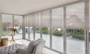 Lounge room with light filtering roller blinds installed to capture the views outside the home